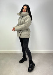 Veste d’hiver courte taupe — vue portée de profil en intérieur, silhouette