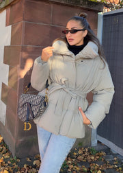 Veste d’hiver courte taupe — vue portée de trois-quarts en extérieur, sac bandoulière noir