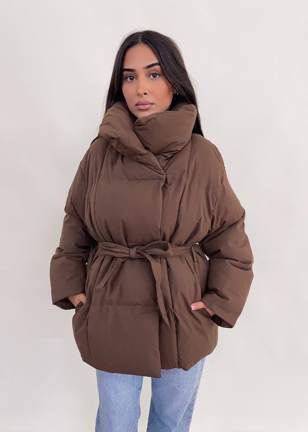 Veste brune matelassée à ceinture — vue de face, ceinture nouée.