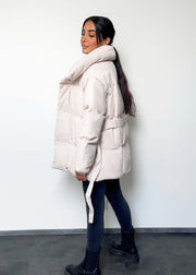 Veste d’hiver courte beige — vue portée de profil, liens de serrage sur les côtés
