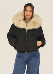 Veste beige large col fourrure — vue portée de face, cadrée à la taille, grande capuche en fourrure