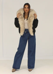 Veste beige large col fourrure — vue portée en pied, ouvert sur un haut côtelé blanc et jean large