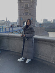 Manteau matelassé gris à ceinture — vue portée en extérieur.