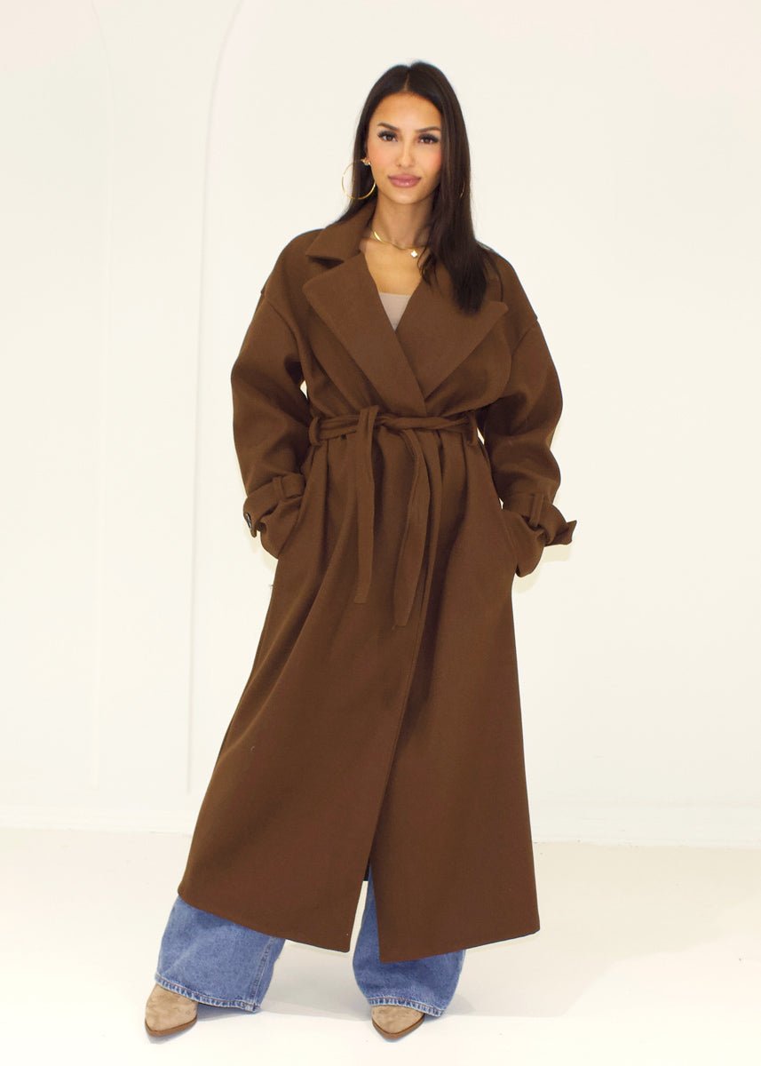 Manteau long brun à ceinture — vue de face, ceinture nouée.