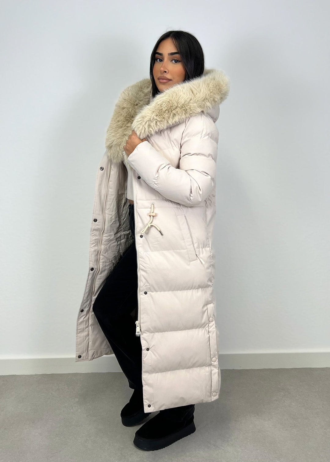 Parka longue beige à fourrure, vue portée de profil