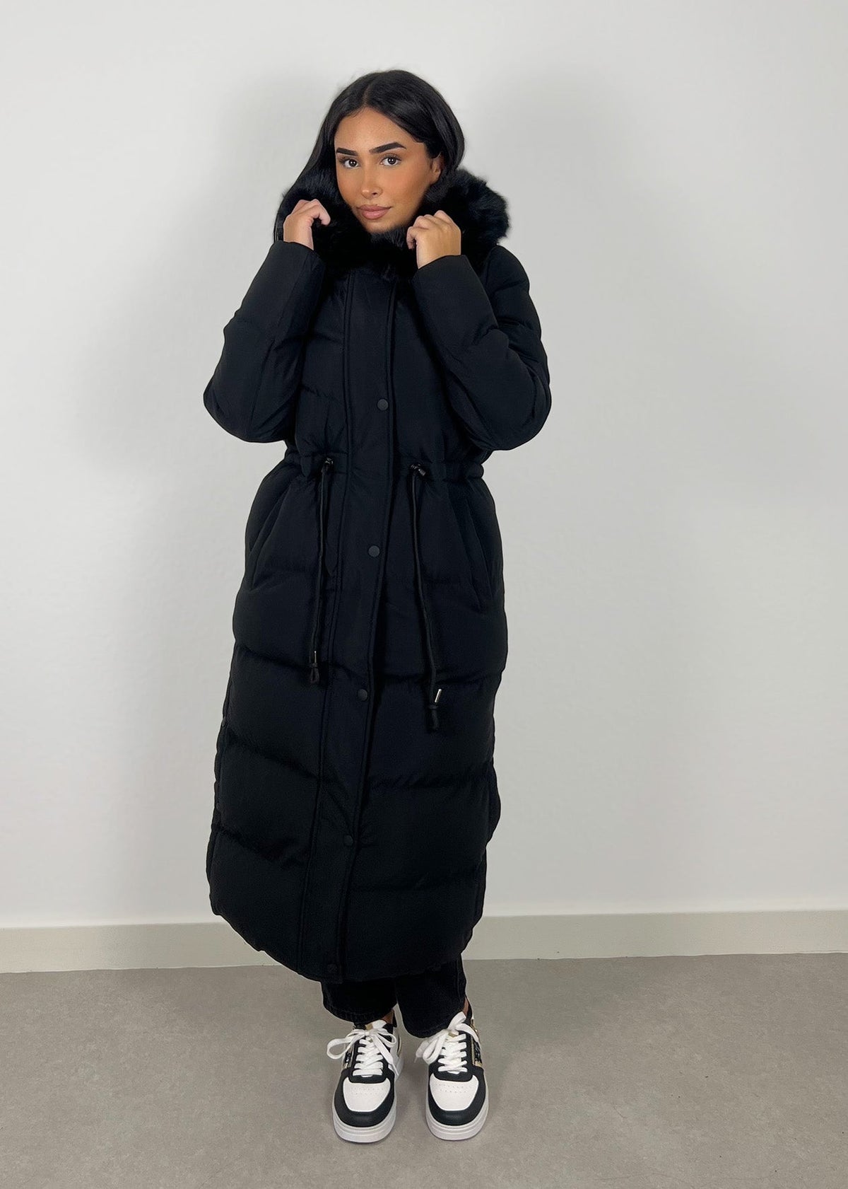 Parka longue noire à capuche — vue portée de face.