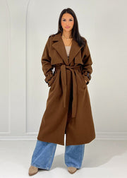 Trench long brun à ceinture — vue portée en pied, ceinturé