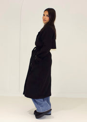 Trench long noir à ceinture — vue portée de dos