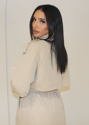 Trench long beige — vue portée de trois-quarts, de dos, regard par-dessus l'épaule
