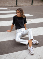 Pantalon effet cuir taille haute porté par une femme, assise, passage piéton, assise