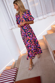 Robe longue cache-cœur fleurie portée par une femme, en marchant, escalier, fente