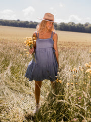 Robe brodée à décolleté carré portée par une femme, vue de face, champ, bouquet