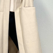 Manteau oversize beige — gros plan du tissu et d'une grande poche plaquée