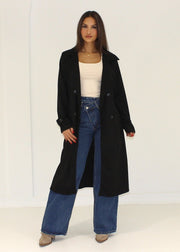Manteau noir effet daim — vue portée en pied, ouvert sur un haut blanc et un jean