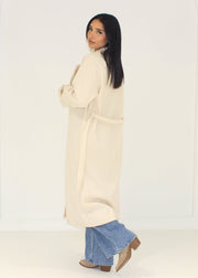 Manteau beige à boutons dorés — vue de dos.