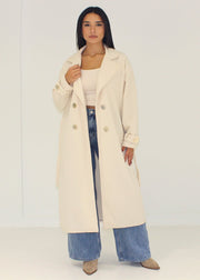 Manteau beige à boutons dorés — vue portée ouverte.