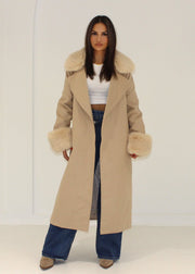 Manteau beige col fourrure ceinture — vue portée en pied, ouvert sur un haut court blanc et jean large