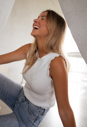 Top pailleté à col montant porté par une femme, vue rapprochée, rire, jean