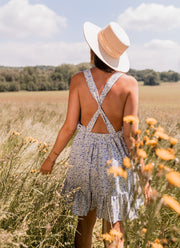 Robe fleurie à volants portée par une femme, vue de dos, bretelles croisées, fleurs jaunes