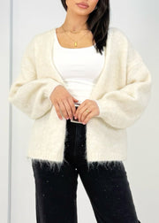 Cardigan maille ouvert beige clair — vue rapprochée de face, cadrée à la taille, sur un haut blanc