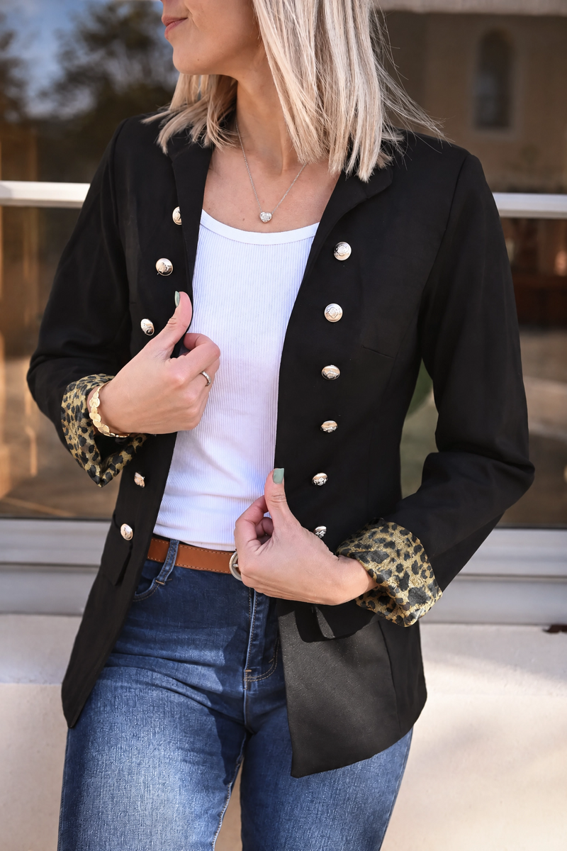 Veste officier à revers léopard portée par une femme, vue rapprochée, boutons dorés, t-shirt blanc