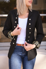Veste officier à revers léopard portée par une femme, vue rapprochée, revers léopard, boutons dorés