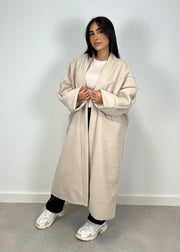 Manteau oversize beige — vue portée de face, mains dans les grandes poches