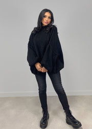 Pull oversize noir — vue portée de trois-quarts, coupe ample et drapée