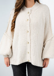 Cardigan oversize beige clair — gros plan de la maille bouclette et des boutons dorés