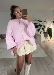 Cardigan oversize rose — selfie au miroir, vue portée en pied, jupe courte beige à volants et bottes blanches