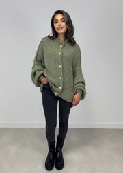 Cardigan oversize kaki — vue portée en pied, jean noir et bottines, fond gris