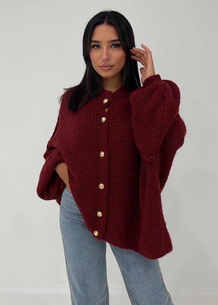 Cardigan oversize bordeaux — vue portée de face, cadrée à la taille, gros boutons dorés et manches ballon