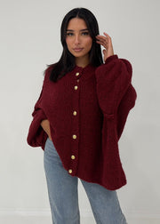 Cardigan oversize bordeaux — vue portée de face, cadrée à la taille, gros boutons dorés et manches ballon