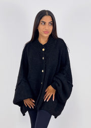 Cardigan oversize noir — vue portée de face, plan moyen, mains sur les hanches
