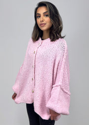 Cardigan oversize rose — vue portée de trois-quarts, regard détourné
