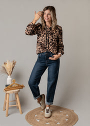 Jean en denim coupe arrondie porté par une femme, vue de trois-quarts, blouse léopard