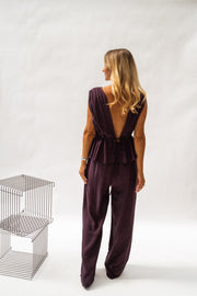 Pantalon fluide en tissu léger porté par une femme, vue de dos, haut aubergine, dos ouvert