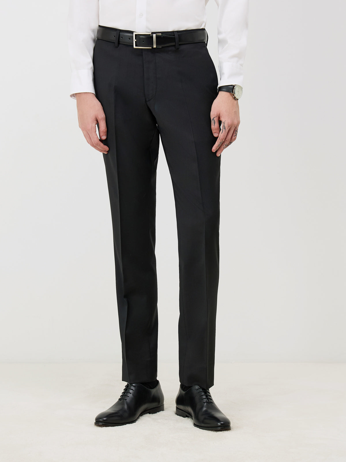 Pantalon regular noir — vue portée de face, cadrée aux jambes