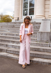 Pantalon droit fluide porté par une femme, vue de face, blazer rose, pantalon droit