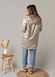 Parka réversible fourrure portée par une femme, vue de dos, côté doré, tabouret