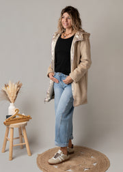 Parka réversible fourrure portée par une femme, vue de trois-quarts, côté doré, sourire