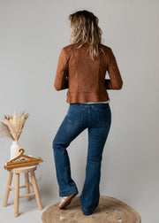 Perfecto en suédine porté par une femme, vue de dos, jean flare, tabouret