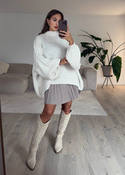 Pull oversize beige clair — selfie au miroir, vue portée en pied, jupe courte et bottes montantes
