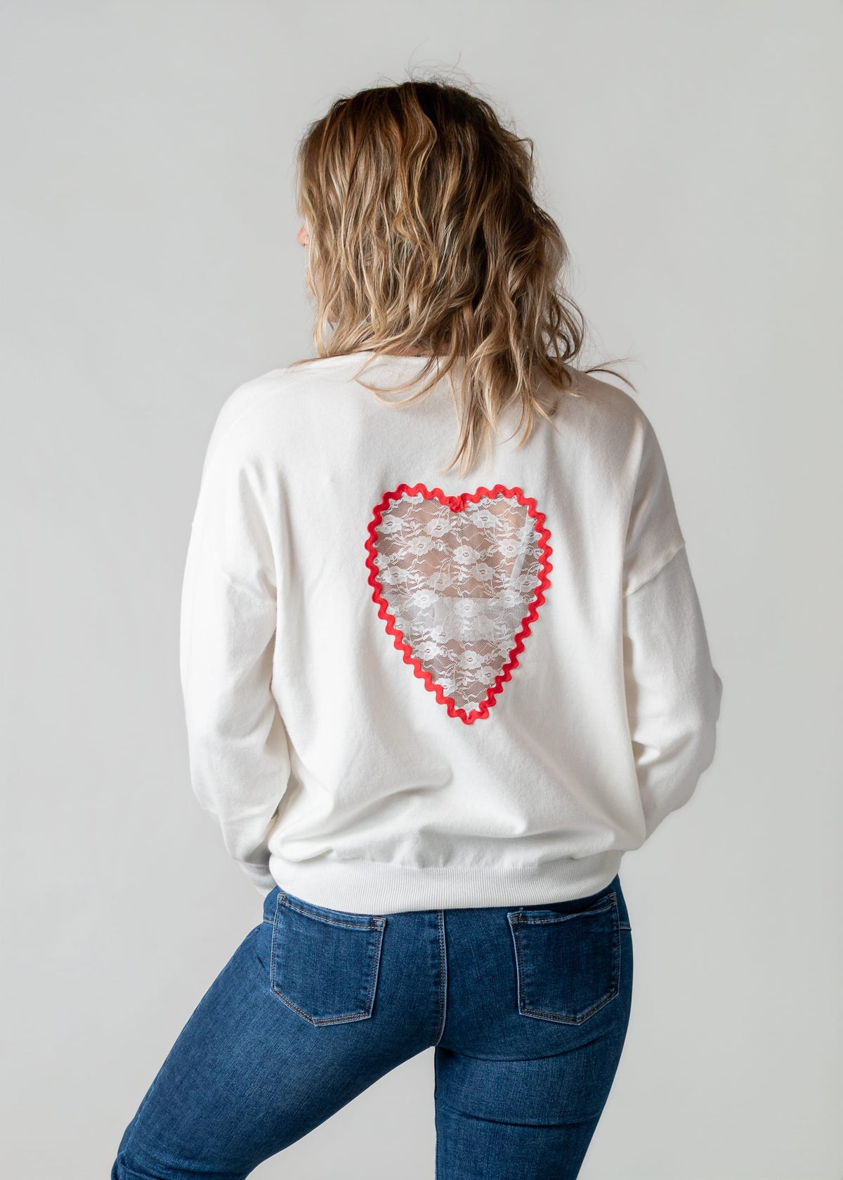Pull fin à dos dentelle porté par une femme, vue de dos, cœur en dentelle, jean