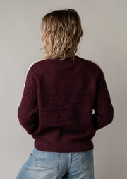 Pull à cœurs brodés porté par une femme, vue de dos, pull bordeaux