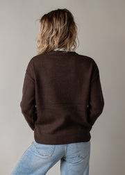 Pull en maille dentelle brodée porté par une femme, vue de dos, pull marron, jean clair