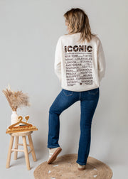 Jean flare à boutons porté par une femme, vue de dos, pull blanc à inscription, jean flare