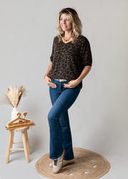 Pull fin col V léopard porté par une femme, vue de trois-quarts, jean flare, pose