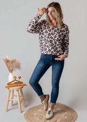 Pull léopard à col V porté par une femme, vue de trois-quarts, main sur la hanche