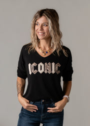 Pull léopard en maille fine porté par une femme, vue rapprochée, pull noir, lettrage pailleté, jean